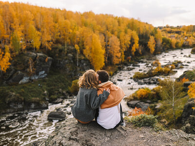 Een jong koppel die uitkijkt op een herfst bos