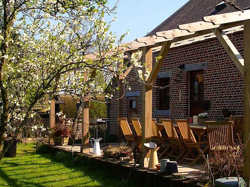 Een zonnige veranda die uitkijkt op een groene tuin met een bloeiende boom in de voorgrond